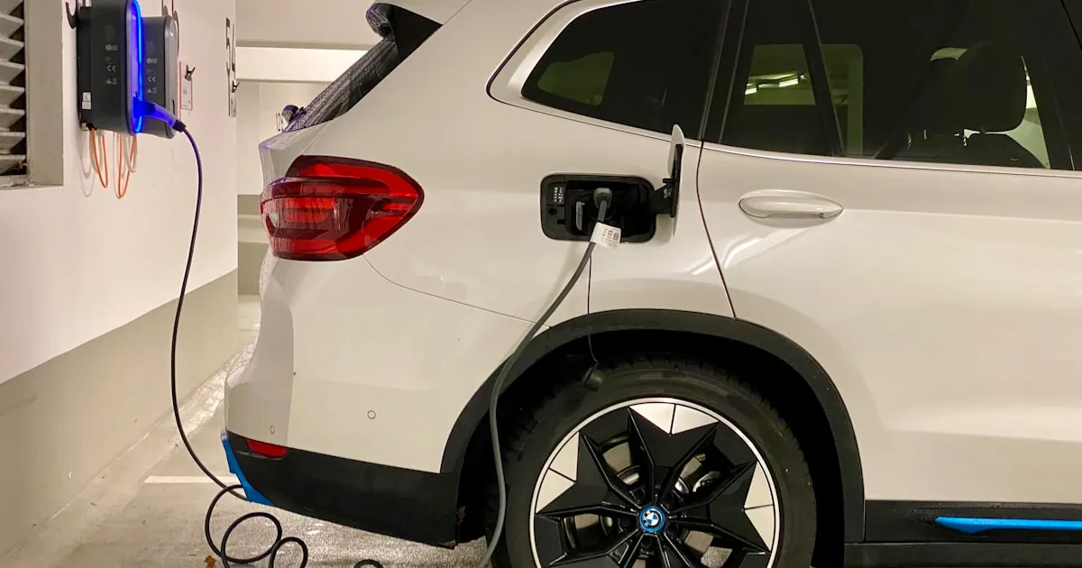 Mașină electrică conectată la o stație publică de încărcare