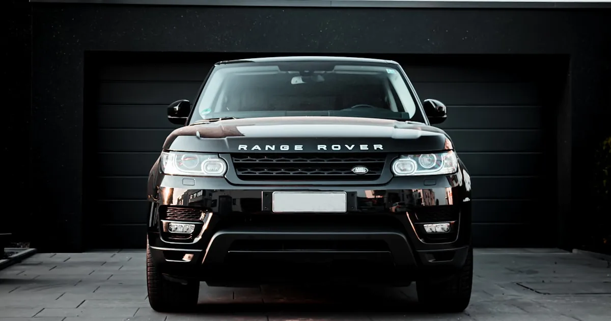 SUV premium negru, fotografiat frontal la ieșirea dintr-un garaj